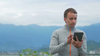 Tablet ile Okyanusu yakınlarındaki sahil boyunca bir adam girer. O sosyal ağdaki iletilerin, denetler ve Fotoğraflar gözatabilir.