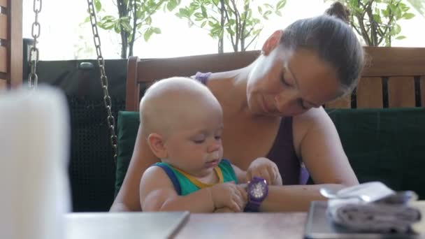 엄마와 아기가 카페에 와서 주문을 기다립니다. 아이는 주위의 모든 사람과 놀고. 아이 1 년 — 비디오