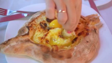 Yumurta ve tereyağı ile fırında peynirli bisküvi. Parlak manikürlü kız bir parça ekmeği batırır. Close