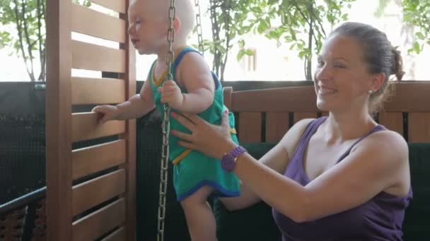 Maman et bébé sont venus au café et ont attendu la commande. Enfant jouer avec tout le monde autour . — Video