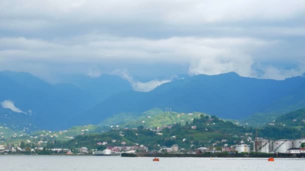 Nádherná scenérie: malé vlny Tichého oceánu, hory v dálce a mraky na obloze před deštěm — Stock video