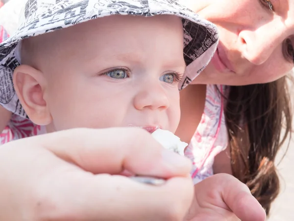 Piękny toddler zwiedzanie z matką na wakacje w mieście. Chłopiec jeść zupę śmietaną ulicy. Dzieciak stylowo ubrane motyl i cap Obraz Stockowy