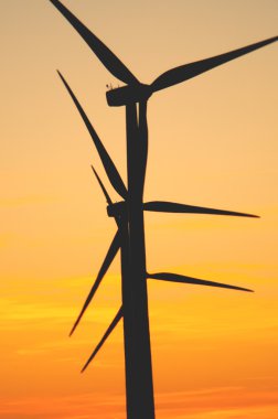 Wind turbine at sunset clipart