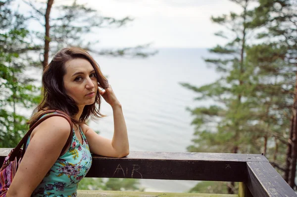 Mädchen sitzt auf der Holztreppe im Park und lächelt — Stockfoto