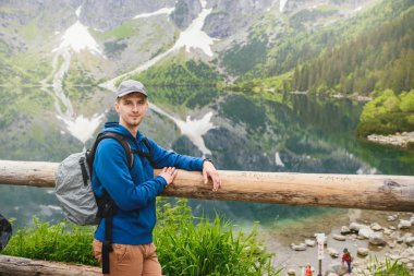 Adam gölde ve dağlarda dinleniyor. Güneşli manzara.