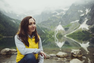 Kadın gölde ve dağlarda dinleniyor güneşli manzara