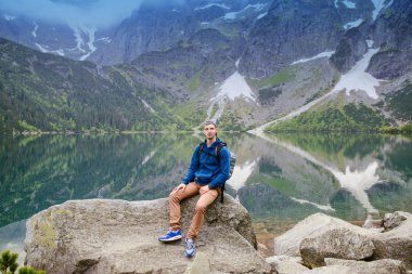 Adam gölde ve dağlarda dinleniyor. Güneşli manzara.