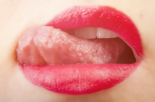 Ritagliato primo piano di una donna che indossa rossetto rosso e leccare il labbro . — Foto Stock