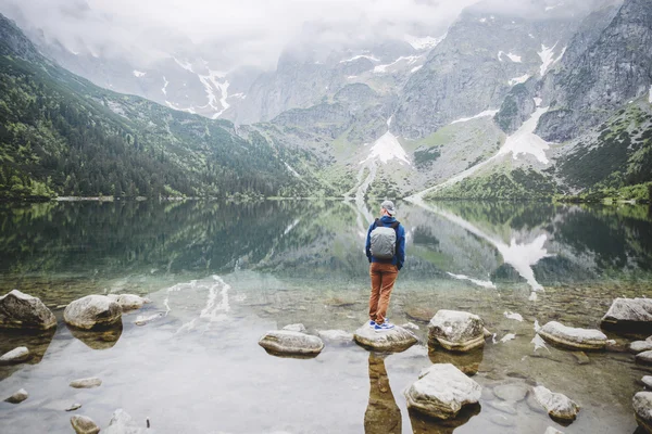 Muž relaxační na jezeře a hory slunné krajiny — Stock fotografie