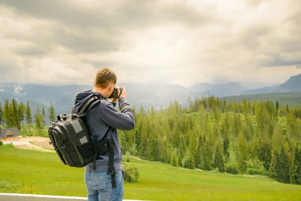 Fotógrafo de la naturaleza tomando fotos en las montañas —  Fotos de Stock