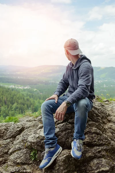 Male resting and enjoying the mountain sitting on rock — Stock Photo, Image