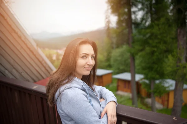 Krásná bruneta dospívající dívka s dlouhými vlasy, opírali se o zábradlí — Stock fotografie