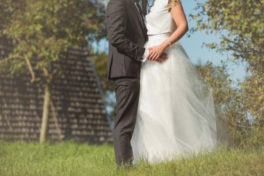 Gelin ve damat doğadaki bir fotoğraf çekiminde. Eski yel değirmeni