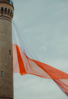 Ulusal bayrağı Polonya 'da olan eski Brick Stone Deniz Feneri. Bulutlu gökyüzü. Bağımsız Gün