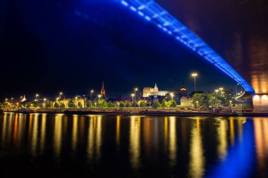 Szczecin. Nehrin karşısından aydınlatılmış tarihi merkeze gece görüşü. Odra Nehri. Szczecin 'deki Chrobry setleri