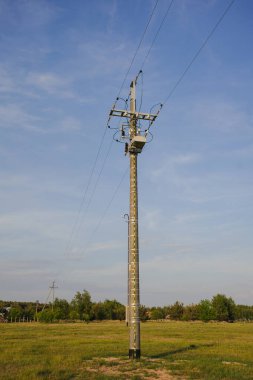 Çayırda yüksek voltajlı elektrik direği yapısı