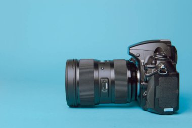Mavi arka plana karşı profesyonel modern DSLR kamera