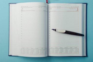 mavi arka plan üstünde defter. Açık günlüğü ve kaydetmek için kalem