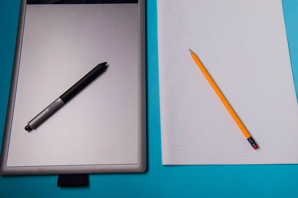 イラストレーターやデザイナーのためのペン付きのグラフィックタブレット対鉛筆と白の白紙 — ストック写真