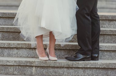 Gelin beyaz düğün ayakkabıları gösteriyor. Düğün ayrıntıları. Kapat.