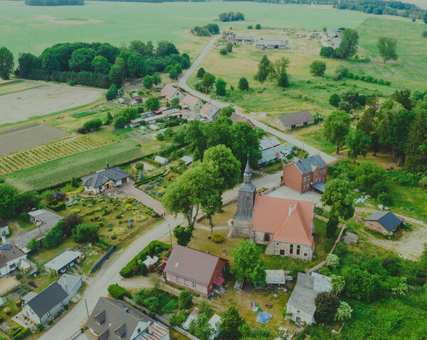 Aerial photo of a typical Polish hosing estate in the mountains towns, taken on a sunny part cloudy day using a drone, showing the housing estate and farmers fields