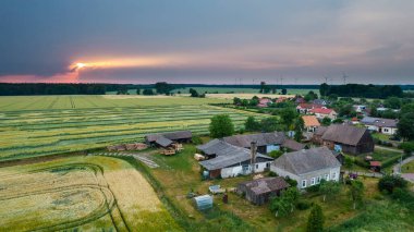 Dağlardaki tipik bir Polonyalı hortum çiftliğinin havadan çekilmiş fotoğrafı. Güneşli bir günde insansız hava aracı ile çekilmiş. Konut arazilerini ve çiftçi tarlalarını gösteriyor.