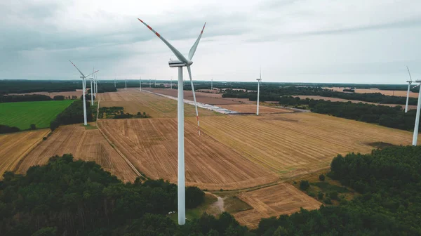 Aerial photo of windmills and blue sea at sunset.