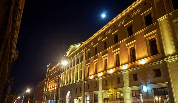 Facciata illuminata dell'edificio e luna — Foto Stock