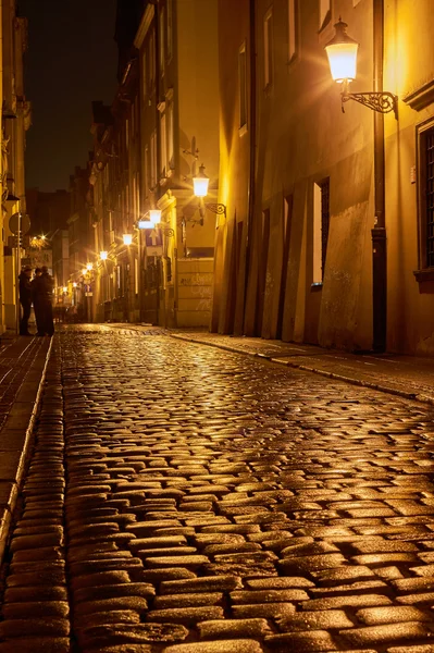 Rainy caminar por la calle adoquinada por la noche en Poznan — Foto de Stock