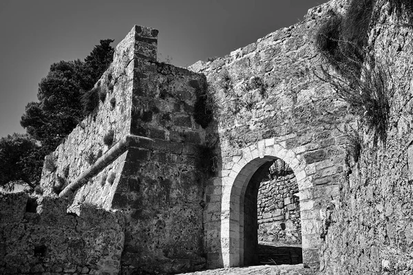Stone gate of the medieval Venetian St George\'s castle on the island of Kefalonia in Greece, monochrome