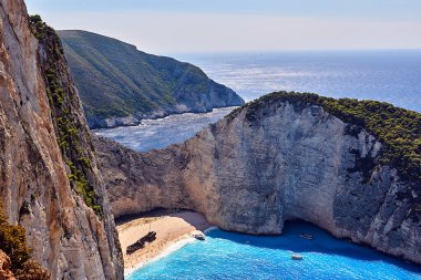 Kayalık kayalıklar, gemi enkazı ve Yunanistan 'ın Zakynthos adasındaki plajda yaşayan insanlar.