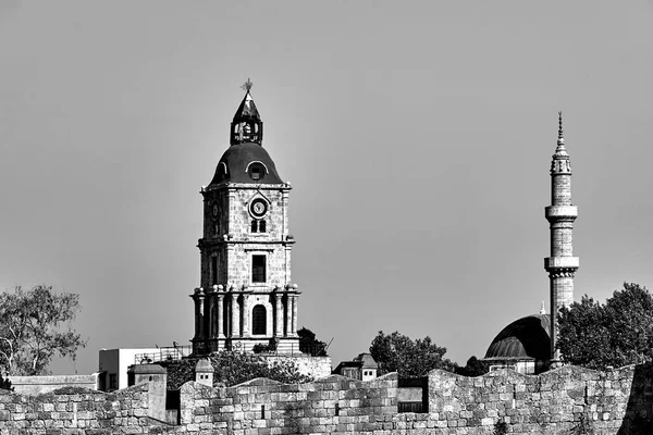ロードス島の中世の防衛壁の後ろの石時計塔とトルコのミナレット — ストック写真