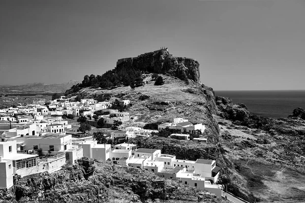 Medieval fortress and white houses of Lindos village in Rhodes, monochrome