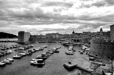 Hırvatistan 'ın Dubrovnik kentindeki ortaçağ kent duvarları ve yat limanı tek renkli.