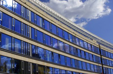 gökyüzü ve bulutlar cam cephe bir binanın içinde yansıma