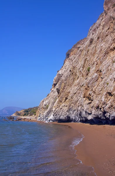 Песчаный пляж и скалистая скала — стоковое фото