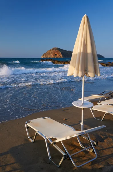 Зонтик на шезлонге на пляже — стоковое фото