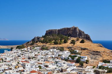 Yunanistan 'ın Rodos adasındaki bir kayanın tepesindeki tarihi şatonun eteğindeki Lindos' un beyaz evleri