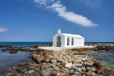 Yunanistan 'ın Girit adasındaki Georgioupoli kasabasında taştan bir burunda beyaz bir Ortodoks şapeli.