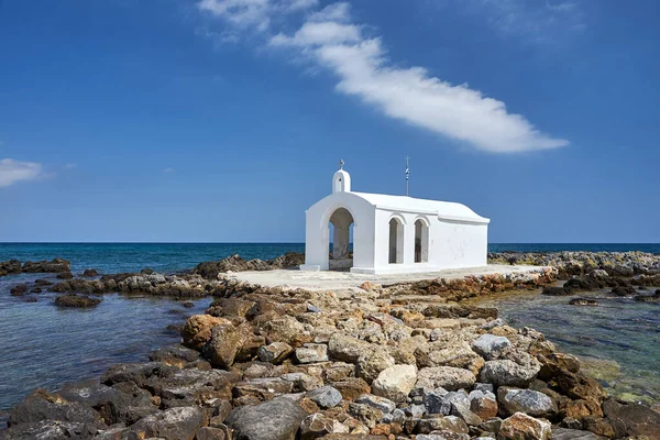 Yunanistan 'ın Girit adasındaki Georgioupoli kasabasında taştan bir burunda beyaz bir Ortodoks şapeli.