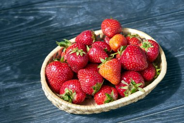 Bahar boyunca hasır bir sepette olgun çilekler, Polonya