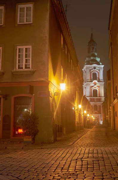 Calle empedrada y torre de la iglesia por la noche — Foto de Stock