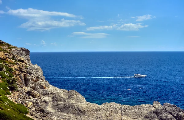 Rodos Adası'nın kayalık kıyısındaki Motorlu tekne — Stok fotoğraf