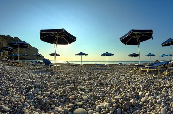 Plaj şemsiyeleri kayalık deniz kenarı — Stok fotoğraf