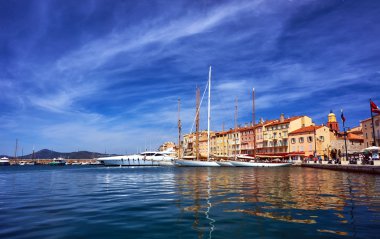 Sailboats and yachts moored to the quay port of Saint-Tropez clipart