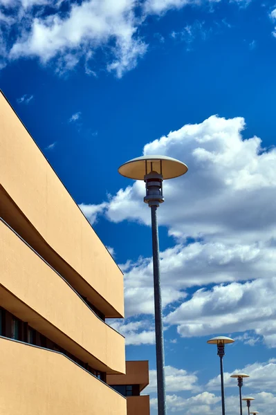 Farolas y un fragmento de la fachada de un edificio moderno contra el cielo —  Fotos de Stock