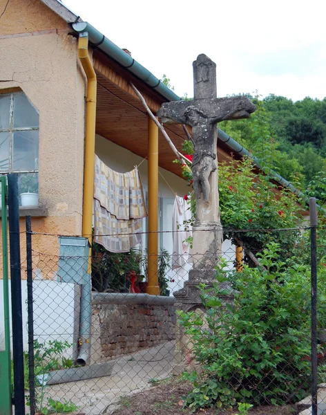 Detail van de oude gevel van het gebouw met kruis in de tuin — Stockfoto