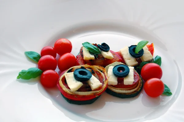 Fatias de abobrinha grelhadas com tomate, azeitonas pretas, queijo de cabra e manjericão — Fotografia de Stock