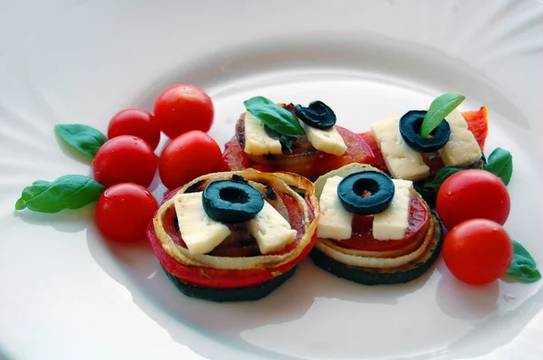 Gegrillte Zucchini-Scheiben mit Tomaten, schwarzen Oliven, Ziegenkäse und Basilikum — Stockfoto