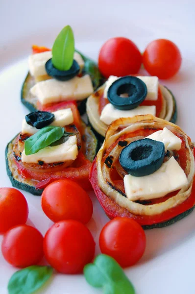 Plastry grillowanej cukinii z pomidory, czarne oliwki, kozim serem i bazylią — Zdjęcie stockowe
